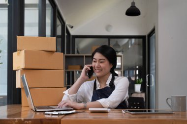 Online business owner are taking on the phone orders for customers, negotiating for delivery.