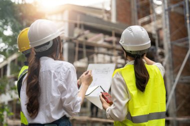 Engineer and Architect working at Construction Site with blue print, Construction concept.