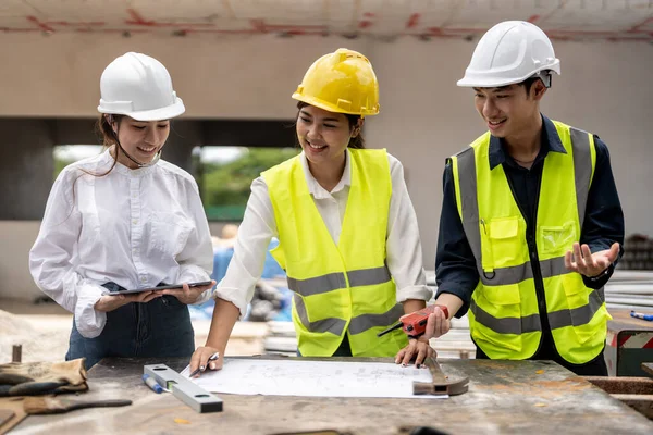 Asian foreman and engineer meeting in house under construction.