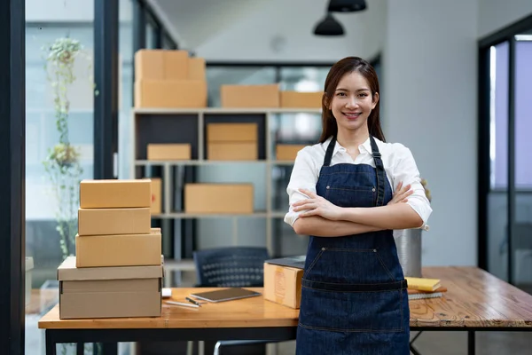 Portrait business Asian woman with parcel shipping box before send to customer. Entrepreneur small business working at home