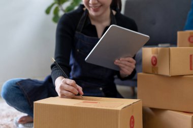 Küçük girişimciler, kahverengi paket kutuları, küçük ev kurma fikirleri olan ürünleri düzenleyerek bir ev kurarlar