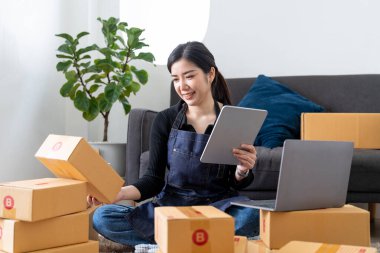 Startup sme business owner using digital tablet checking order from customer online purchase shopping order