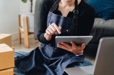 Startup sme business owner using digital tablet checking order from customer online purchase shopping order