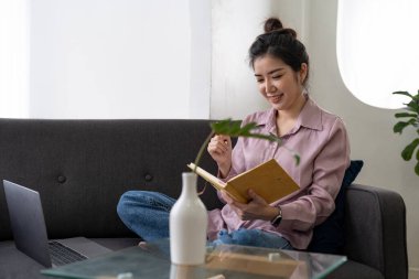 Asian young female using laptop listen and learning online courses at home