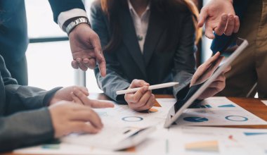 Bir grup iş adamı, pazarlama planının verilerini analiz etmek için toplanıyor.