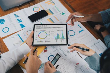 İşletme danışmanlığı ortaklığı ortakları şirketin mali durumunun grafiğini çıkarmak için tablet kullanıyorlar..