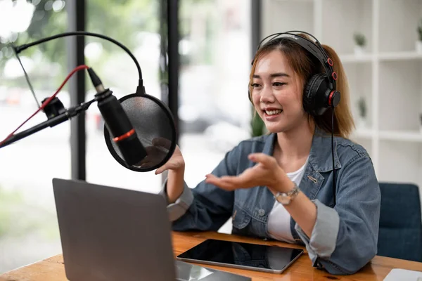 Young asian woman makes a podcast audio recording at home