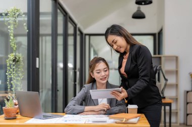 Asian business woman adviser talk, consult, discuss working with new startup project idea presentation analyze plan marketing and investment in the office