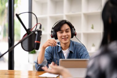 Man and woman podcasters interview each other for radio podcast.