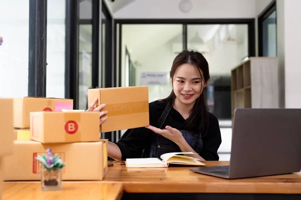 Young start up business woman asian working as SME entrepreneur new business with packaging box, preparing for send to client