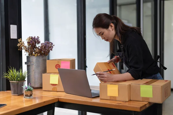 Young start up business woman asian working as SME entrepreneur new business with packaging box, preparing for send to client