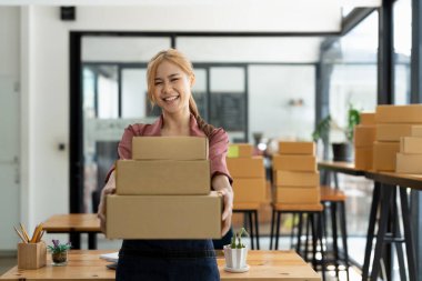 Portrait young attractive asia female owner startup business working with carton box at home prepare delivery in sme supply chain, procurement.