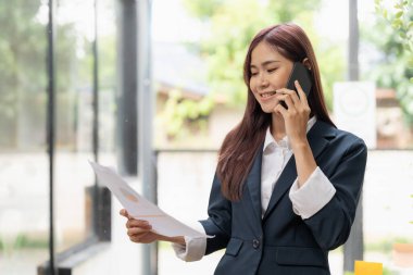 Portrait of young office assistant working remotely online with paperwork financial document