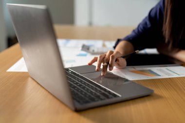 Hesap makinesi ve dizüstü bilgisayar kullanan, belgeleri okuyan, mali durumları kontrol eden, faturaları ya da vergileri sayan, online bankacılık hizmetleri olan genç bir kadın..