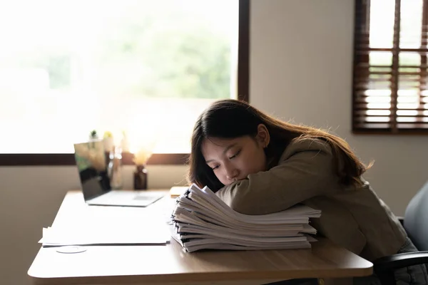 Tired business asian woman feel exhausted and stressed with stack of financial documents