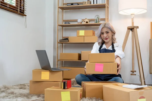 Asian SME business woman with order online shipping parcel boxes at home. Starting Small business entrepreneur SME freelance. Online business, Work at home concept