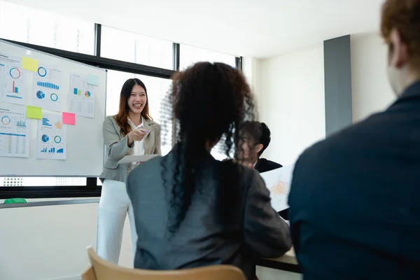 woman supervisor boss teach diverse staff workers explain project plan paperwork at group meeting, focused black female mentor training business team at corporate office briefing