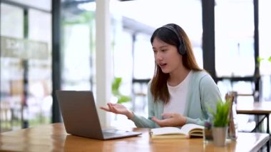 Asyalı kız öğrenci dizüstü bilgisayarı kullanarak uzaktan eğitim semineri, uzaktan üniversite webinarı ya da üniversitenin yaratıcı alanında sanal sınıf toplantısı yapıyor..
