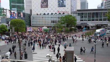 Tokyo 'daki ünlü Shibuya Geçidi' ni yürüyerek geçen bir kalabalık var..