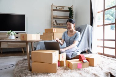 Asyalı işletme sahipleri müşterilerle video aracılığıyla iletişim kurmak için dizüstü bilgisayar kullanıyorlar. Evde çalışırken çevrimiçi..