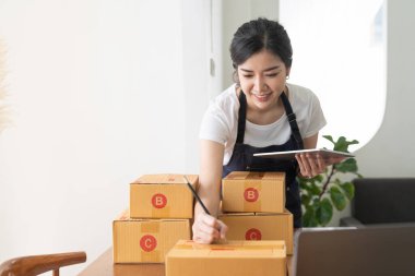 Evde portre genç Asyalı küçük işletme sahibi, çevrimiçi pazarlama paketleme ve teslimat sahnesi, başlangıç KOBİ girişimcisi veya ev konseptinde çalışan serbest meslek sahibi.