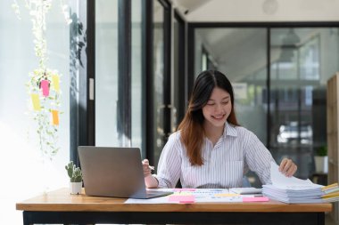 Muhasebe planlama bütçe kavramı - İşkadını ofisleri tamamlanmamış belge yığınlarını düzenlemek için çalışıyor.
