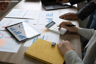 İş adamları grubu, işletme işletme giderleri ve şirketlerin mali durumları hakkındaki iş verilerinin özet grafik raporlarını analiz eder.