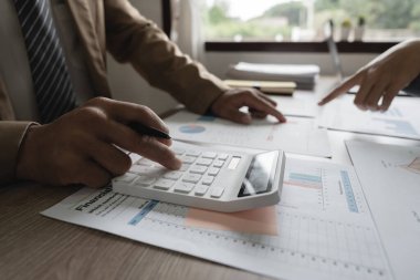 İş yeri verilerini, muhasebe belgelerini ve ofisteki dizüstü bilgisayarları, iş konseptini hesaplamak için hesap makinesi üzerinde çalışan iş adamı ya da muhasebecinin el kalemini kapat.