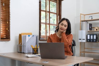 Bilgisayarda çalışırken boynu ağrıyan Asyalı iş kadını. ofis sendromu kavramı
