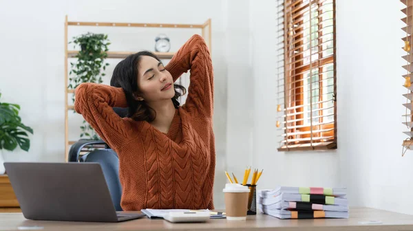 Businesswoman or working lady is stretch themselves or lazily for relaxation on their desk while doing heir work in the office