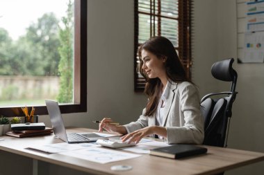 Ofiste hesap makinesi ve bilgisayar kullanan kadın muhasebeci, finans ve muhasebe kavramı
