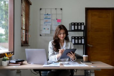 Ofiste hesap makinesi ve bilgisayar kullanan kadın muhasebeci, finans ve muhasebe kavramı