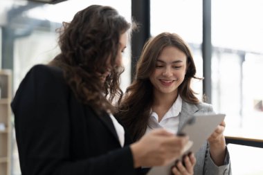 Çeşitli iş adamları birlikte çalışarak şirket mali istatistiklerini tartışıyor, çok ırklı meslektaşlar tabletteki finansman ile beyin fırtınası yapıyor
