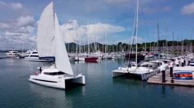 Yelkenli yelkenli katamaran iskeleye çok yakın.