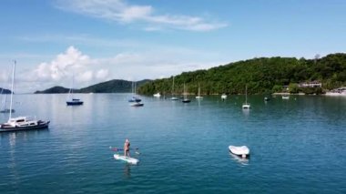 Phuket, Tayland, 08 Eylül 2020: Yaşlı bir kadın sabah körfezin körfezinde ayakta duruyor, insansız hava aracının görüntüsü