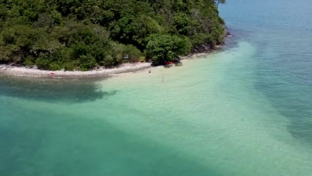 小さな熱帯の島の砂州に沿って水からカップルが現れます — ストック動画