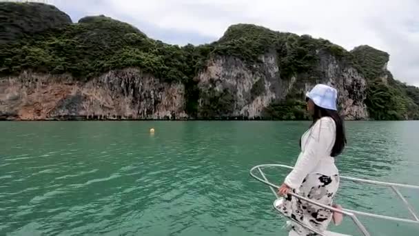 タイの女の子はセーリングカタマランでのボート旅行中にパンガー自然保護区について話します — ストック動画