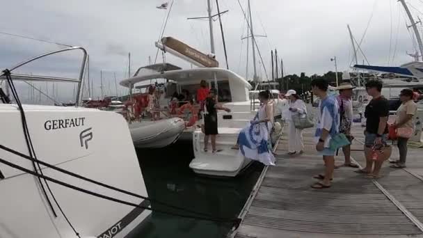 アジアの観光客はボート旅行のために港にセーリングカタマランに乗ります — ストック動画