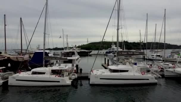 ヨットマリーナの桟橋には帆船のカタマランが係留され ドローンからの眺め — ストック動画