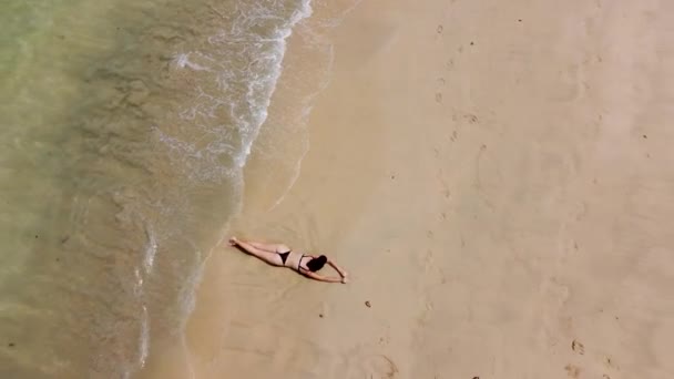 一个女孩躺在热带海滩的海岸上 从无人驾驶飞机上俯瞰着 — 图库视频影像