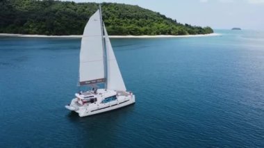 Yükselen yelkenleri ve yavaş çekim videosu olan tropikal bir adadan güzel bir yelkenli.