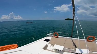 Gemi, Andaman Denizi boyunca bir tekne gezisi sırasında yelkenli katamaranın tahtasından yavaşça denize açılır.