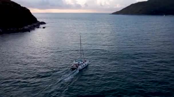 夕日に海に浮かぶカタマランのセーリング 海に浮かぶセーリングボートが波に乗っています — ストック動画