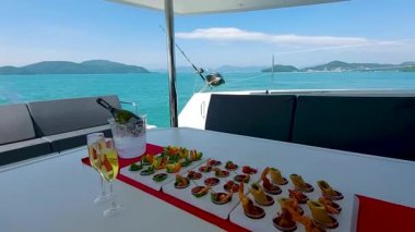 Yelkenli katamarana şampanya ve aperatifler, tekne gezisi konukları için yiyecek ve içecek.