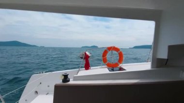 Tropikal adalar boyunca dalgalar boyunca yelken açan yelkenli bir katamaranın kokpitinden görüntü