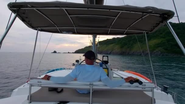 仕事の後にセーリング カタマランの船長が休んでる男は夕方にセーリング ボートで休んでる — ストック動画