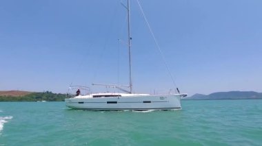 Yelkensiz yelkenli teknesi dalgalarda yüzer, denizde yelkensiz yatla gezer.