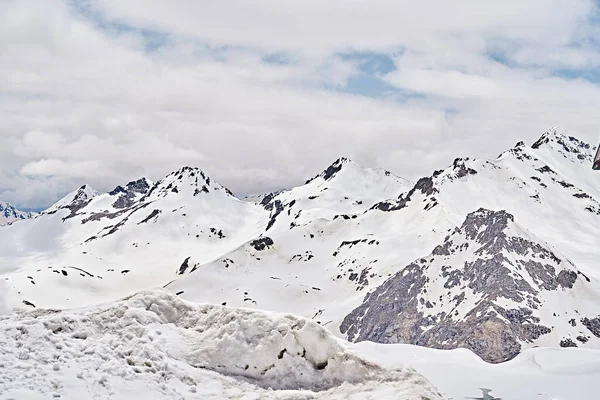 Mayıs 'ta Elbrus Dağları. Kar, yeşillik, kahverengi toprak