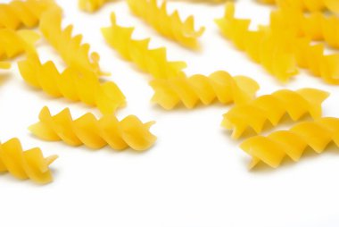 Fusilli İtalyan makarnası beyaz arka planda yayılmış.