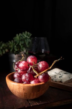 Mavi peynirli üzümler, lezzetli bir aperatif ya da tatlı için mükemmel bir kombinasyon. Koyu yiyecek fotoğrafçılığı